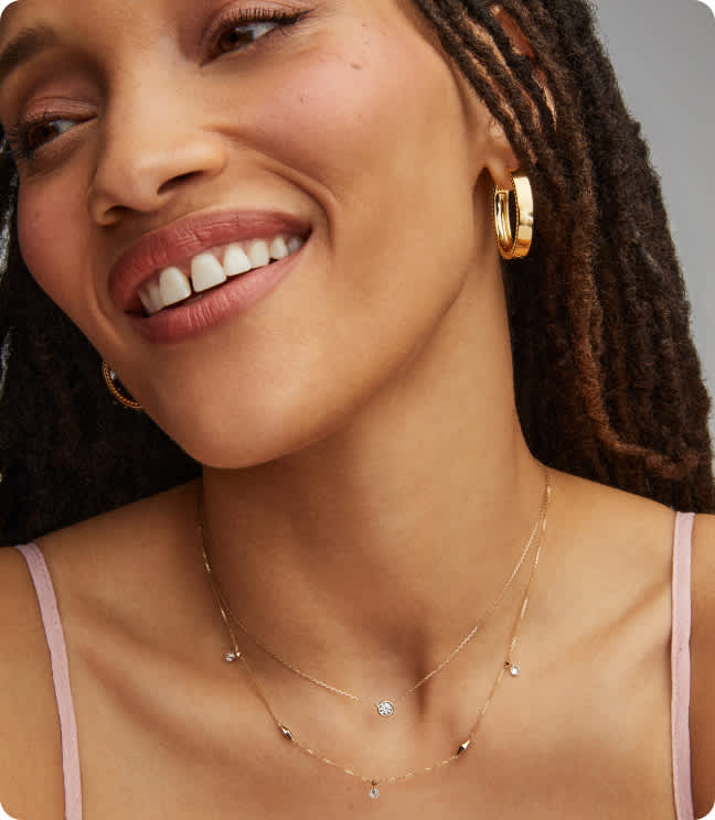 Image of model wearing earrings and two necklaces.